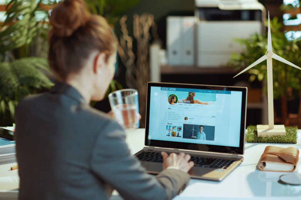 Woman reading social media updates on her laptop, illustrating how treatment centers manage engagement and avoid common social media mistakes.